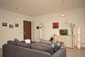 sala de estar con sofá y TV en Va Pensiero sul lago Stunning View, en Tronzano Lago Maggiore