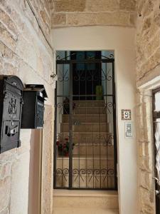 einen Eingang zu einem Gebäude mit einem schwarzen Tor in der Unterkunft Ex Monastero Pieno Centro storico in Bitetto