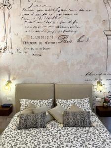 ein Schlafzimmer mit einem Bett und einer Wand mit Unterschriften in der Unterkunft Ex Monastero Pieno Centro storico in Bitetto
