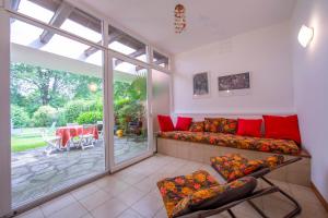 uma sala de estar com um sofá e uma grande janela em Rododendro Rosso - Happy.Rentals em Ispra