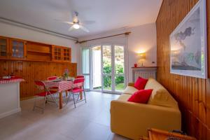uma sala de estar com um sofá e uma mesa em Rododendro Rosso - Happy.Rentals em Ispra