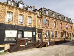 a large red brick building with flags in front of it at The Originals Boutique, Hôtel Aultia, Ault in Ault
