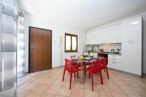 cocina con mesa y sillas rojas en una habitación en Le Betulle Garden in Laveno, en Laveno-Mombello