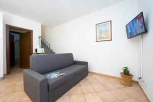 sala de estar con sofá y TV en Le Betulle Garden in Laveno, en Laveno-Mombello