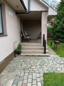 a patio with two chairs and a bench on a house at Family house room in Salacgrīva