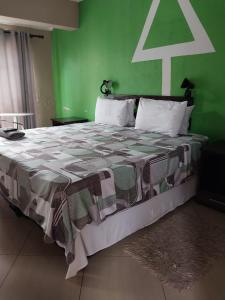 a bedroom with a large bed with a green wall at Nomanini guest house Nelspruit in Nelspruit