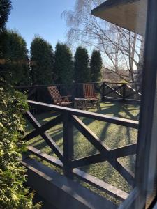 2 chaises et une table sur une clôture dans l'établissement Family house room, à Salacgrīva