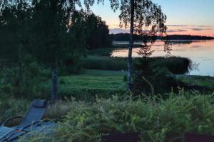 een bankje naast een meer bij zonsondergang bij Talo rannan läheisyydessä in Karvsor