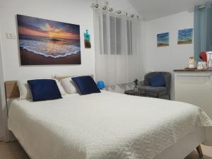 um quarto com uma grande cama branca com almofadas azuis em בית המזל em Bete-Seã
