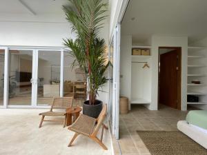 a living room with a potted plant and chairs at New!2BR,400M to the Beach Cemagi in Tanah Lot