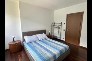 a bedroom with a bed with a blue striped comforter at Riflessi sul lago apt – Laglio in Laglio