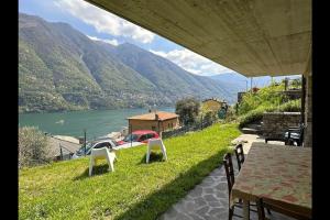 a table and chairs with a view of a lake at Riflessi sul lago apt – Laglio in Laglio