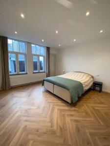 a bedroom with a bed and a wooden floor at Apartement City Center Gouda: View Deluxe in Gouda