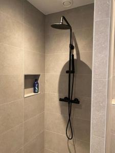 een douche met een zwarte douchekop in de badkamer bij Apartement City Center Gouda: View Deluxe in Gouda