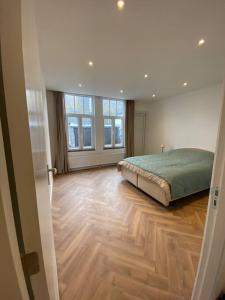 een slaapkamer met een groot bed en houten vloeren bij Apartement City Center Gouda: View Deluxe in Gouda