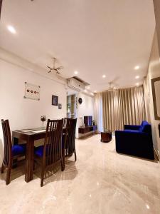 a dining room and living room with a table and a couch at City Nest 1 BHK in Hiranandani Powai (C) in Mumbai