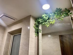 une salle de bains avec une décoration végétale sur le mur. dans l'établissement City Nest 1 BHK in Hiranandani Powai (C), à Mumbai
