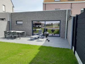 a patio with a grill and a table and chairs at Chez Jeannine et Yvo in Mai Cornet