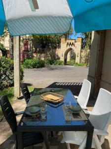 einem blauen Tisch mit Stühlen und einem Sonnenschirm in der Unterkunft Château de la Grange Fort in Issoire