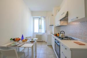 a kitchen with a table and a stove top oven at Casa Al Caprifoglio 600 Mt From Beach - Happy Rentals in Ispra