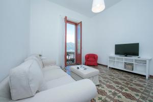 a living room with a white couch and a television at Residenza Oleandro Lake View Luino Center in Luino