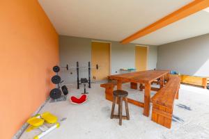 Zimmer mit einem Holztisch und einigen Geräten in der Unterkunft Villa Laura Private Pool and Garden in Besozzo
