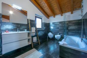a bathroom with a tub and a sink and a toilet at Villa Laura Private Pool and Garden - Happy Rentals in Besozzo +48 photos