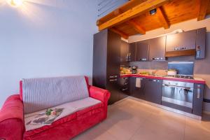 un soggiorno con divano rosso in cucina di Relax al Moro Apt with Pool a Reno Di Leggiuno