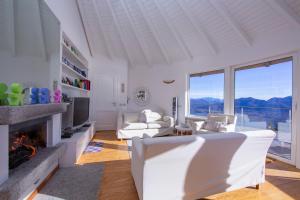 sala de estar con muebles blancos y chimenea en The Perfect View Loft en Premeno