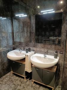 een badkamer met 2 wastafels en een spiegel bij La Casa de Ana in El Barco de Ávila