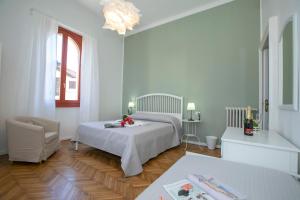 a bedroom with a bed and a chair in a room at Residenza Gardenia Lake View Luino Center - Happy Rentals in Luino