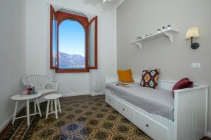 a bedroom with a bed and a table and a window at Residenza Gardenia Lake View Luino Center - Happy Rentals in Luino