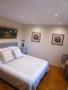 um quarto com uma cama e duas fotografias na parede em Au Fil de l'Eau em Mouroux