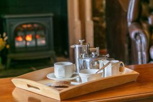 un vassoio di legno con tazze e una macchinetta del caffè su un tavolo di East Hook Farmhouse a Haverfordwest