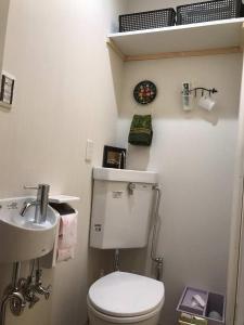 a small bathroom with a toilet and a sink at 百合の家 in Shimmachidōri