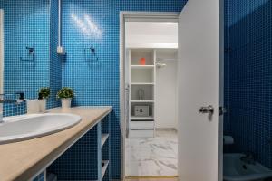 baño con lavabo y azulejos azules en T0 Vilamoura Downtown, en Vilamoura 15 fotos más