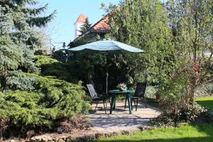 - une table et des chaises avec un parasol dans le jardin dans l'établissement Rozika guesthouse - Sukoró, à Sukoró