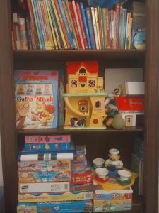 a book shelf filled with books and a toy house at La casa di Tommy in Cortona