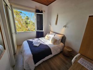 a bedroom with a bed with a large window at Hôtel Au Bon Landais in Biscarrosse-Plage
