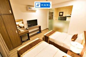 pokój hotelowy z dwoma łóżkami i telewizorem w obiekcie HANZ MyMy Hotel w Ho Chi Minh