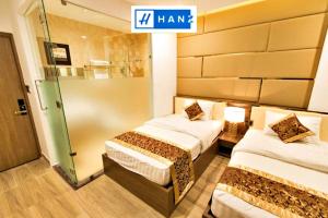 a hotel room with two beds and a sign that sayshare at HANZ MyMy Hotel in Ho Chi Minh City