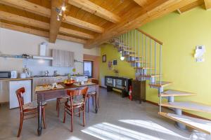 kuchnia ze stołem i krzesłami oraz schodami w obiekcie Casa Baroni few min from Orta Lake - Happy Rentals w mieście Madonna del Sasso