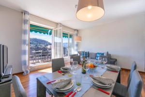 a dining room with a table and chairs and a television at Appartamento Il Golfo Lake View in Laveno-Mombello