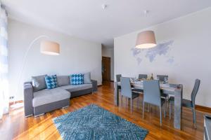 a living room with a couch and a table and chairs at Appartamento Il Golfo Lake View in Laveno-Mombello