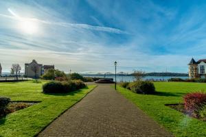 a walkway through a park next to a body of water at Penthouse at the Bay near Edinburgh in Saint Davids