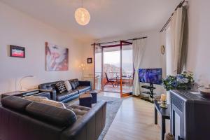 een woonkamer met een bank en een tv bij La Bellavista Penthouse in Stresa