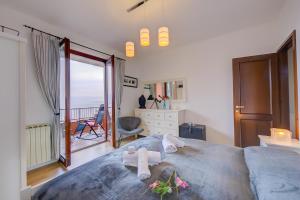 een slaapkamer met een bed met handdoeken en een balkon bij La Bellavista Penthouse in Stresa