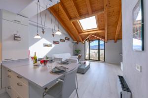 een keuken met witte werkbladen en een houten plafond bij Blu Lake apartment on Ghiffa Beach in Ghiffa