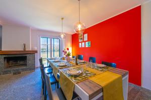 a dining room with a long table and a red wall at Villa Giulietta Family Child Friendly - Happy Rentals in Gemonio