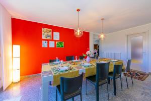 a dining room with a red wall and a table and chairs at Villa Giulietta Family Child Friendly - Happy Rentals in Gemonio